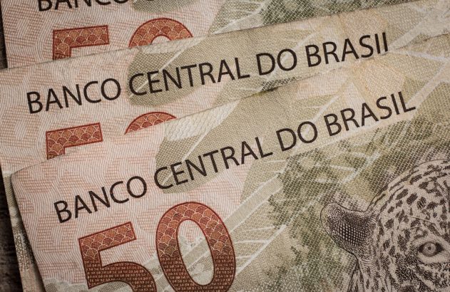 Notas de R$50 do Brasil em close-up, mostrando "Banco Central do Brasil" e a onça-pintada.