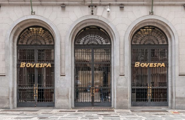 Fachada do prédio da Bovespa, com três grandes arcos e janelas com grades, exibindo o nome BOVESPA em dourado.
