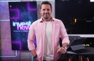 Apresentador de camisa rosa em estúdio do InvestNews, em pé e olhando para a câmera.