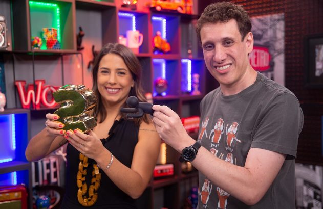 Duas pessoas sorrindo; a mulher segura um "2" dourado e o homem, uma figura preta.