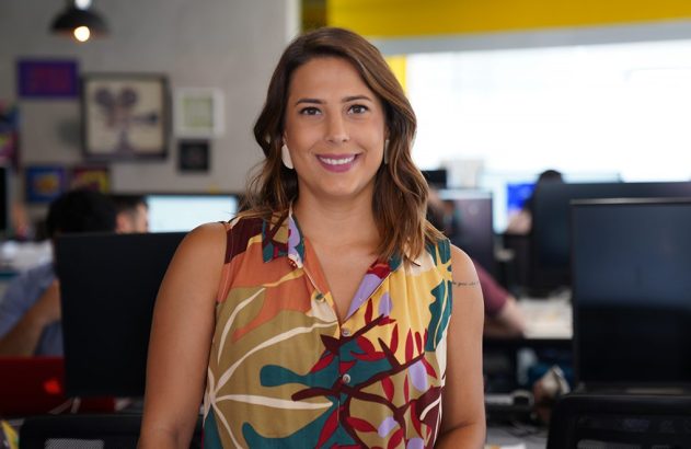 Mulher sorridente com blusa colorida em escritório.