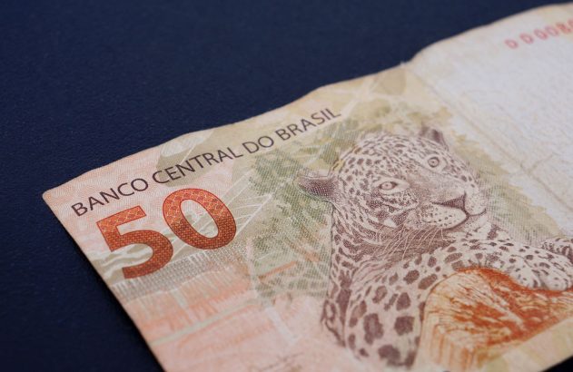 Cédula de 50 Reais do Brasil com uma onça-pintada, em close-up, sobre fundo azul-escuro.