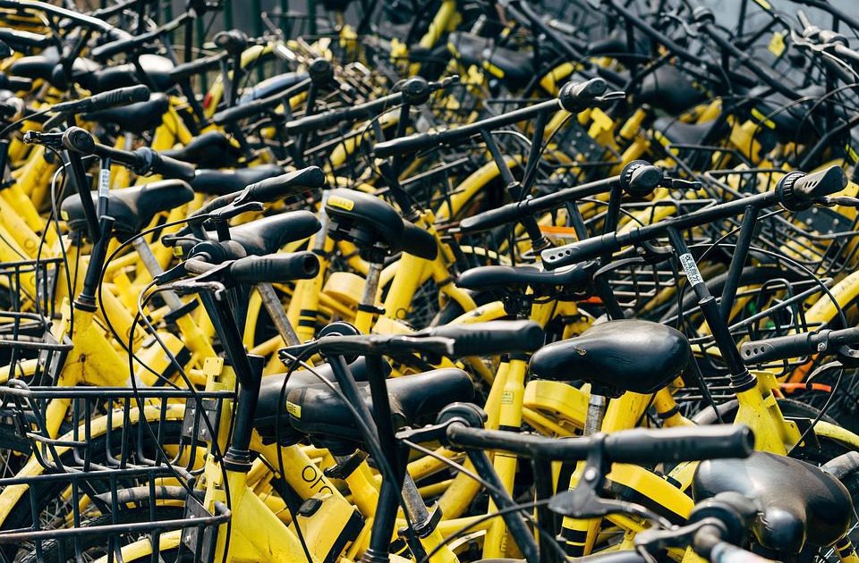 Pilha maciça de bicicletas amarelas e pretas entulhadas.