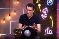 Homem gesticula à câmera em cenário com dólar dourado, esfera e neons de finanças e crescimento.