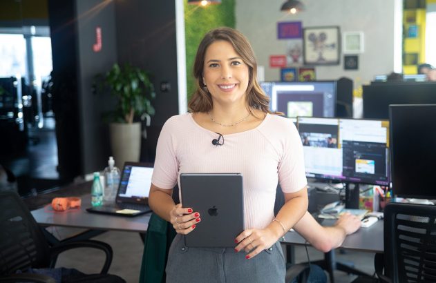 Mulher sorridente com tablet em escritório.