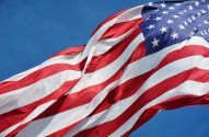 Bandeira dos EUA tremulando contra céu azul.
