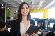 Mulher profissional sorridente com tablet em escritório ativo.