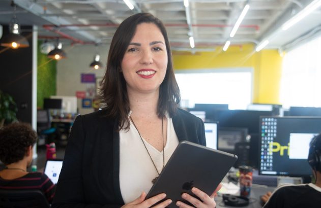 Mulher profissional sorridente com tablet em escritório ativo.