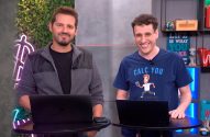 Dois homens sorrindo, um de camiseta azul "CALC YOU", em pé atrás de laptops em um estúdio.