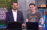 Dois homens sorrindo para a câmera em estúdio, com laptops à frente e decorações ao fundo.