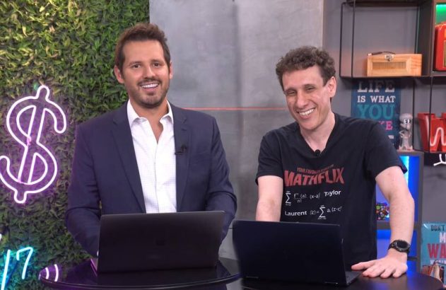 Dois homens sorrindo, um de camiseta MATHFLIX, com laptops em estúdio, prontos para apresentar conteúdo.