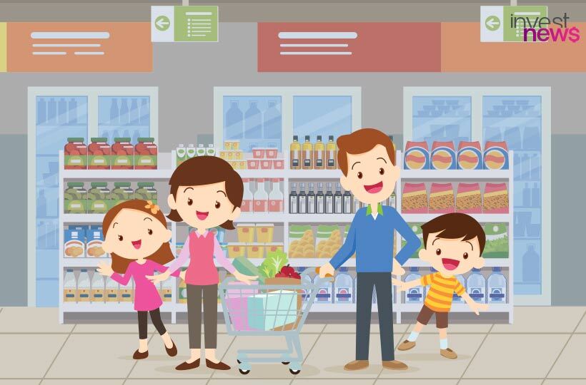 Família (pai, mãe, filha, filho) sorrindo e fazendo compras no supermercado com um carrinho.