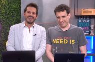 Dois homens sorrindo em estúdio com laptops. Um usa jaqueta clara, outro camiseta escura.