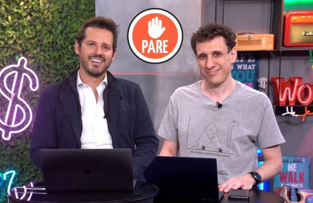 Dois homens sorrindo em estúdio, sentados com laptops. Ícone grande "PARE" em destaque.