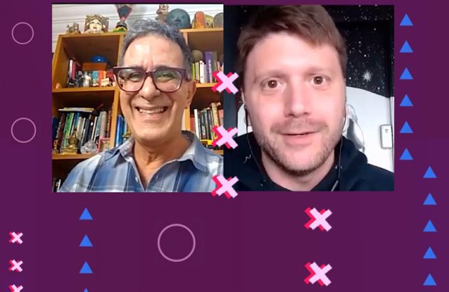 Dois homens em videochamada, tela dividida. Um sorri e usa óculos, o outro tem barba. Fundo roxo.