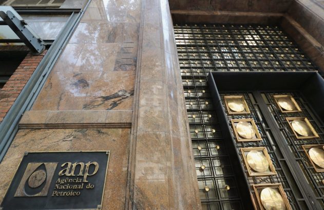 Fachada de prédio em mármore com placa "ANP Agência Nacional do Petróleo" e portão metálico ornamentado.