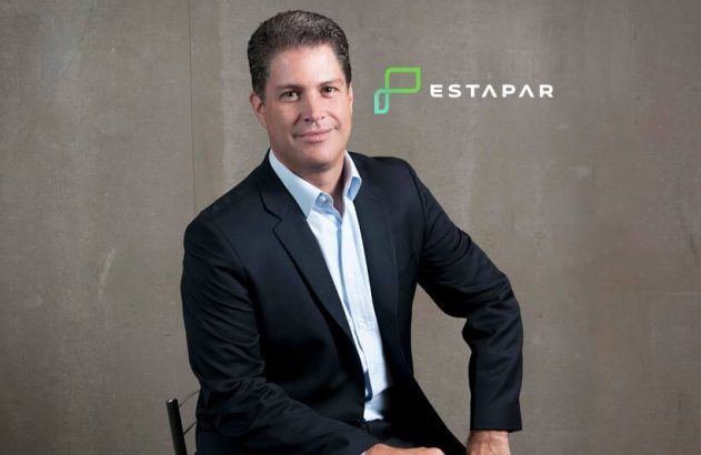 Homem de terno sentado, olhando para câmera, com logo Estavar.