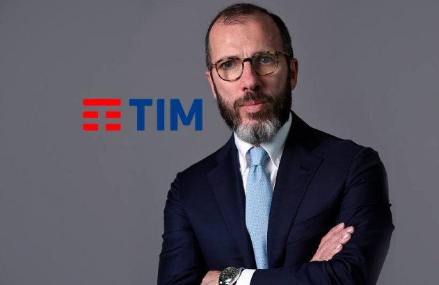 Homem de terno e óculos, braços cruzados, com logo TIM.