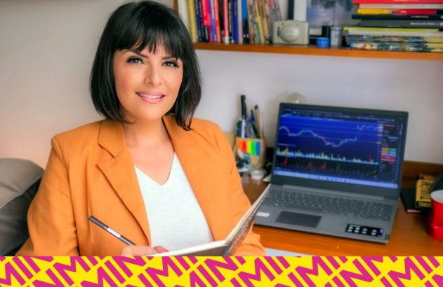 Paula Reis sentada em frente ao computador, segurando um caderno e uma caneta