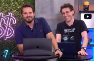 Dois homens sorrindo atrás de mesas com laptops em um estúdio com fundo verde e neon.