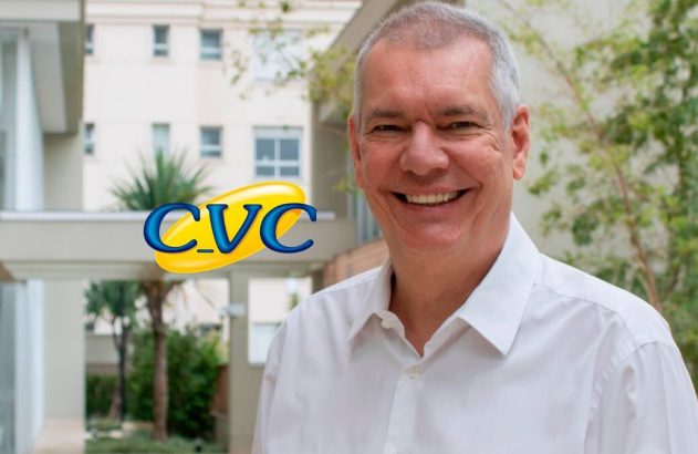 Homem sorridente de camisa branca, com logo CVC, em ambiente com arquitetura moderna e plantas.