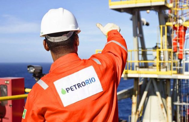 Funcionário da Prio dando um joia para outro funcionario em plataforma de petróleo