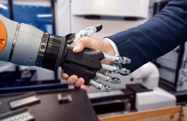 Mão humana e mão robótica apertando-se.