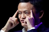 Jack Ma pensativo, com os dedos nas têmporas, em close-up contra fundo escuro.