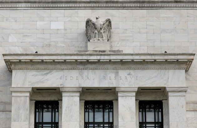 Fachada de mármore branco do Federal Reserve com o nome "FEDERAL RESERVE" e uma águia no topo.
