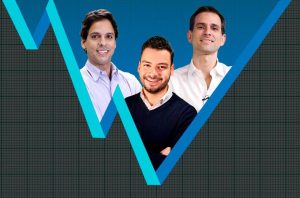 Três homens sorrindo em um gráfico de linha azul em formato de W, com fundo quadriculado escuro.