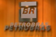 Logotipo BR e Petrobras em vidro fosco, com fundo laranja desfocado.