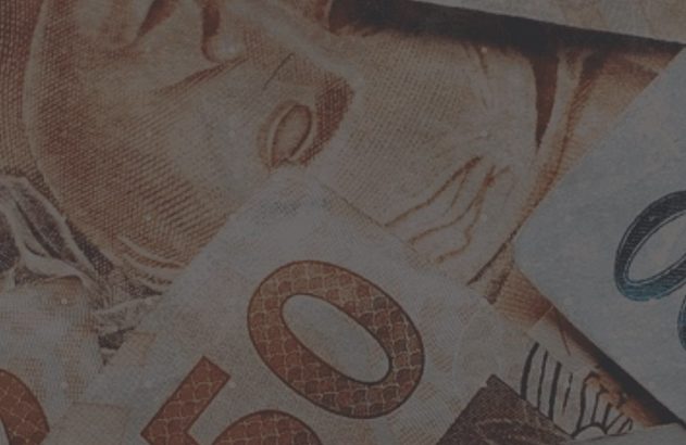 Notas brasileiras de 50 e 100 Reais sobrepostas.