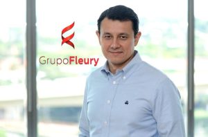 Homem em camisa azul clara com o logo do Grupo Fleury.