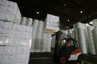 Empilhadeira carrega fardos de papel em fábrica da Suzano