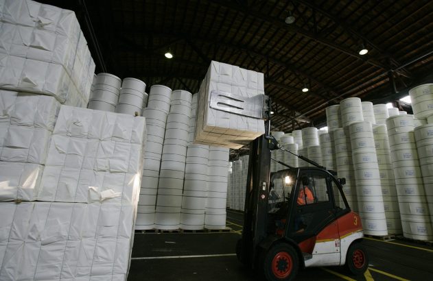 Empilhadeira carrega fardos de papel em fábrica da Suzano