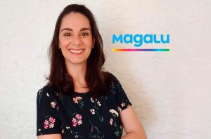 Mulher sorrindo com blusa floral. Ao lado, o logo azul Magalu com uma linha colorida.
