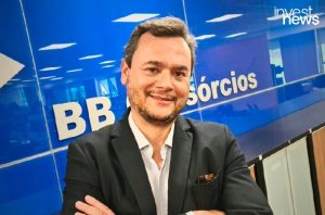 Homem sorrindo de blazer, braços cruzados. Fundo azul com logo "BB" e "Investnews".