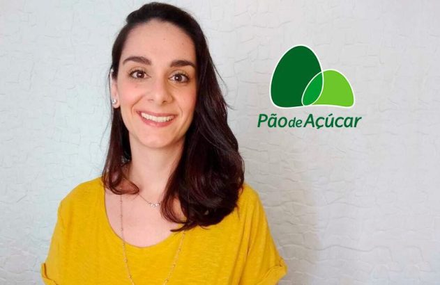 Mulher sorrindo para a câmera, com blusa amarela. Ao lado, o logo Pão de Açúcar.