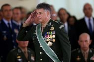 Militar fardado de verde escuro, com medalhas e faixa, prestando continência.
