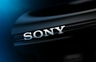 Logotipo SONY 3D prateado em superfície preta brilhante com luz azul.