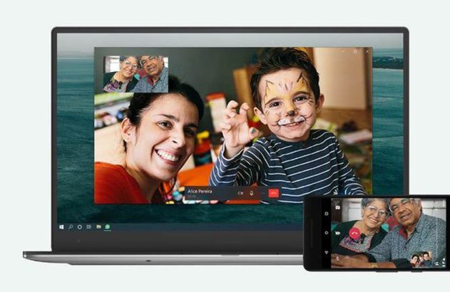 Laptop e smartphone em videochamada familiar: mulher, criança com rosto pintado e casal de idosos.