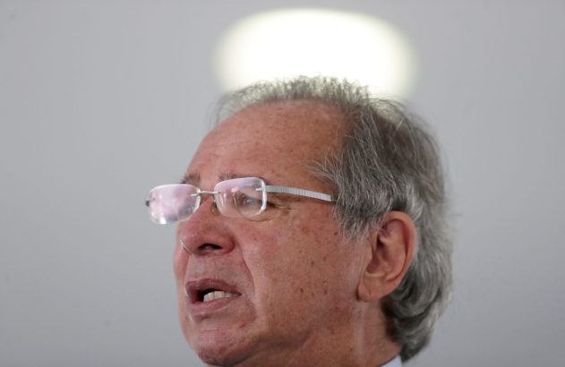 Homem de óculos com cabelos grisalhos e boca aberta, como se estivesse falando, em close-up lateral.
