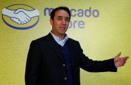 Homem em terno apresentando, com logotipo Mercado Livre e ícones de e-commerce ao fundo.