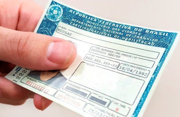 Uma mão segurando CNH brasileira de Nicolas, válida até 07/07/2020.