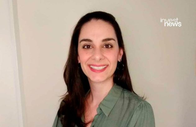 Mulher sorrindo olhando para a câmera com logo "invest news" no canto superior direito.