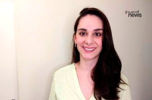 Mulher sorrindo. Logo Invest News no canto superior direito.