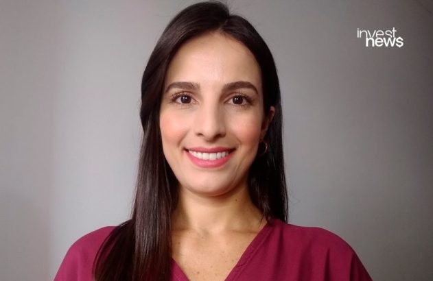 Retrato de mulher com cabelo escuro sorrindo. Fundo cinza com logo 'invest news'.