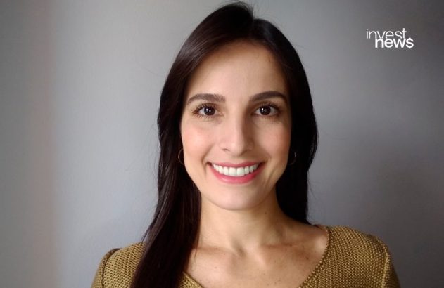 Retrato de mulher sorrindo, com cabelo escuro e blusa dourada. Logo "invest news" no canto superior direito.