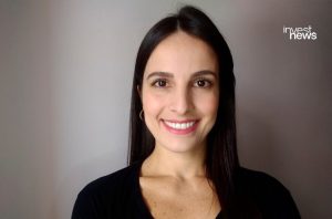 Retrato de mulher sorrindo para a câmera, com cabelo escuro e blusa preta.