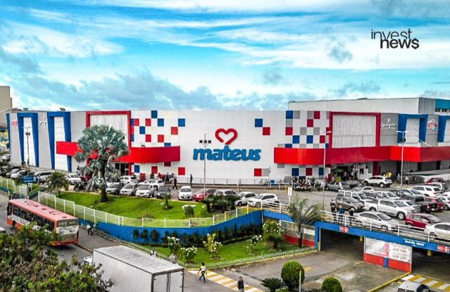 Supermercado Mateus de fachada colorida, com estacionamento cheio de carros e pessoas. Ônibus e caminhão na rua.